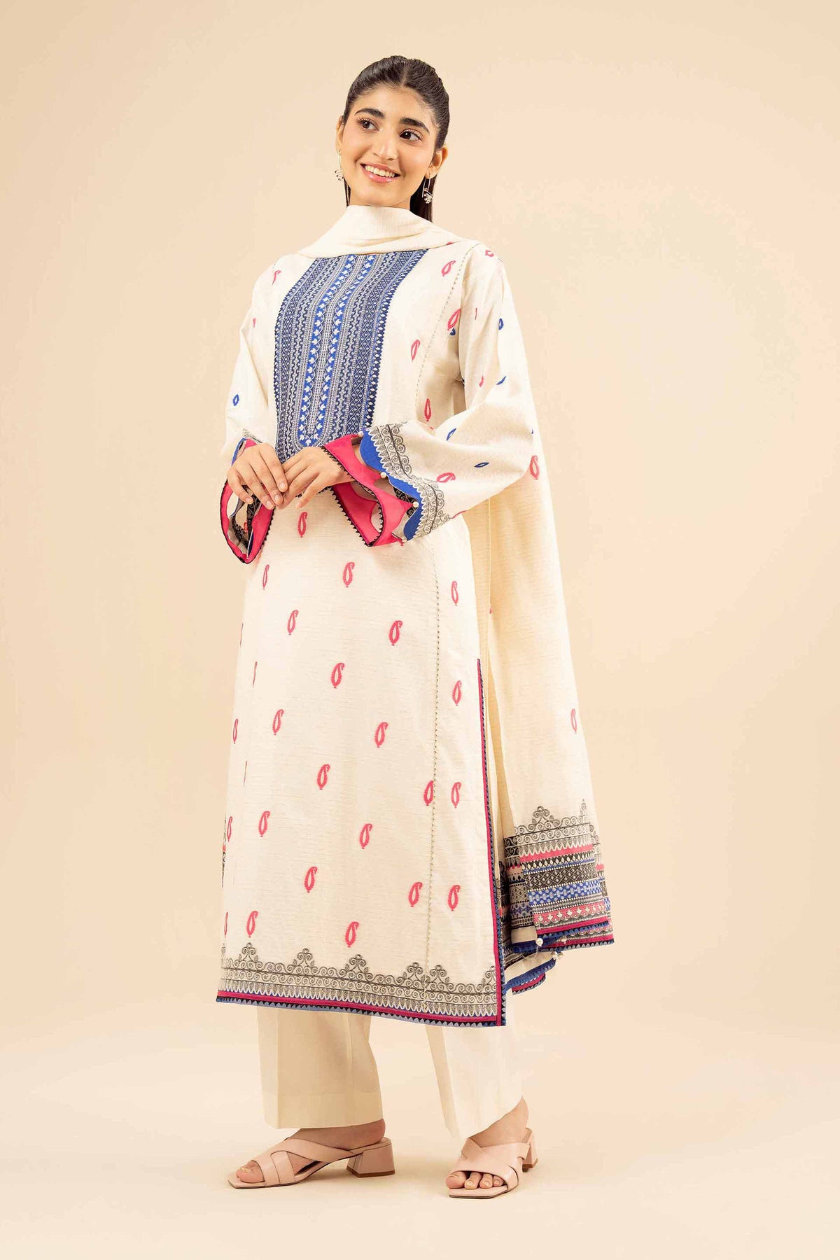 White printed 3-piece suit with pink motifs, blue neckline, matching trousers and bordered dupatta